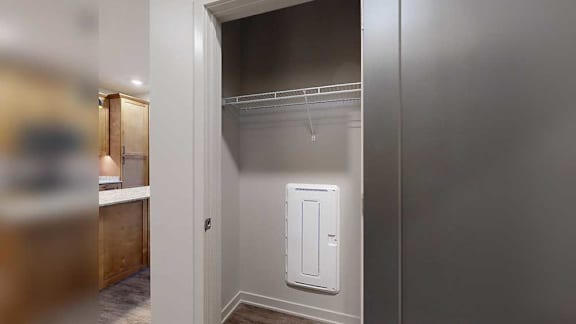 a storage closet in the front entry with a built-in wire shelf