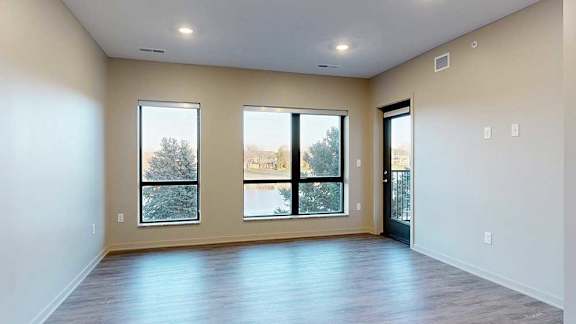 a living room with two large windows overlooking the pond