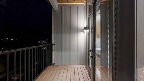 A balcony view at night with a glass door