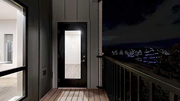 A balcony with a night view of trees with lights