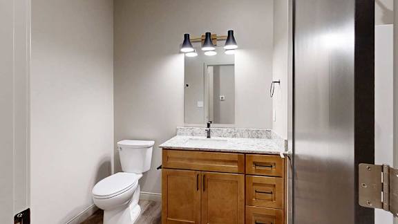 a bathroom with a toilet, sink, and mirror.
