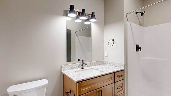 A bathroom with a white sink, and a mirror.