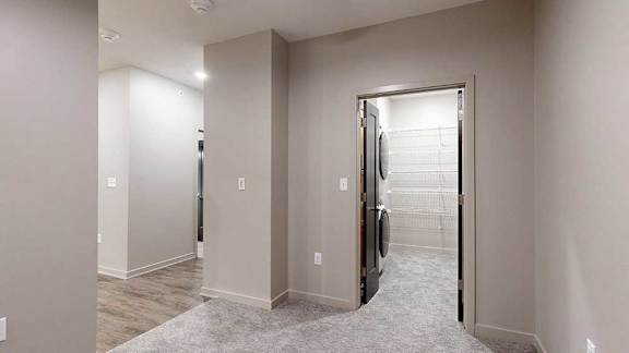 sleeping area with a washer and dryer in the closet.
