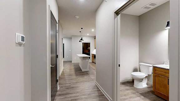 entry of apartment with hallway, bathroom, and kitchen