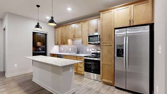 A modern kitchen with wooden cabinets and stainless steel appliances.