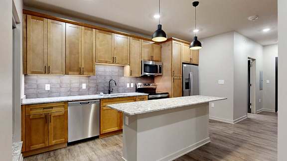 A kitchen with wooden cabinets and a granite countertop.