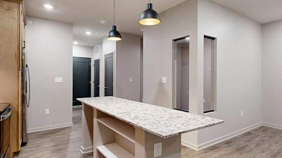 A kitchen with a table and a refrigerator.