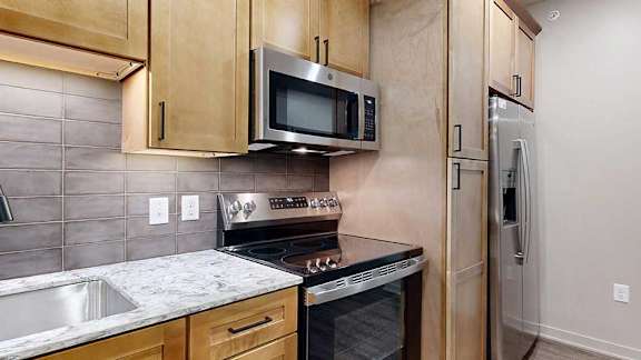 A kitchen with a stove top oven and microwave above it.