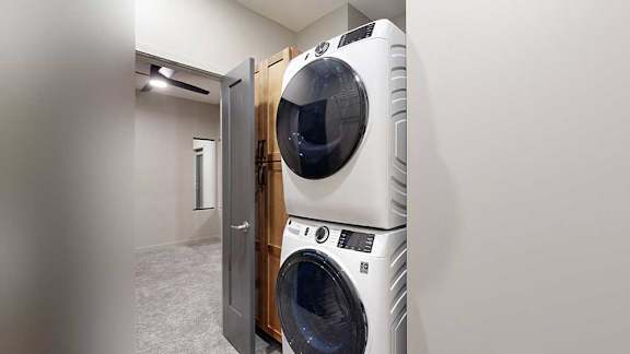 A white front loading washing machine is in a laundry room.