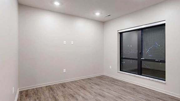 A room with a window and wooden flooring.