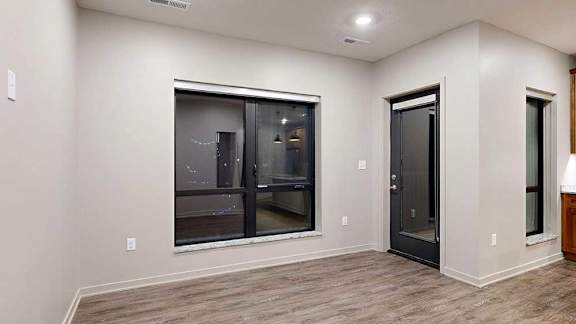 a living room with a glass door and a black door.
