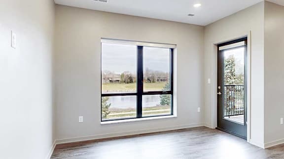 Living room with large window and natural light, adjacent to sleeping and kitchen areas.