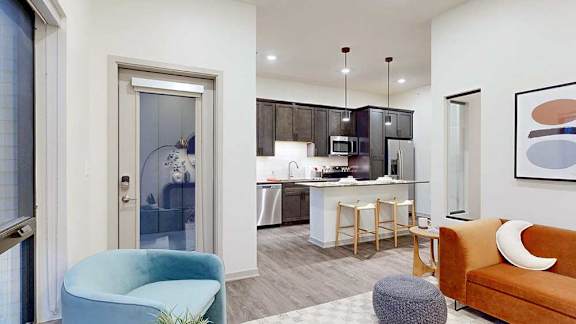 a living room with access to the balcony and seating for guests