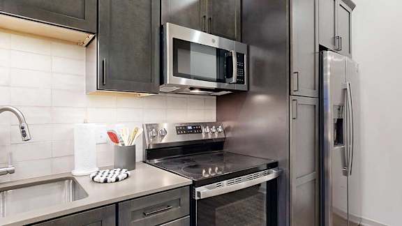 a modern kitchen with stainless steel appliances and a microwave above the stove