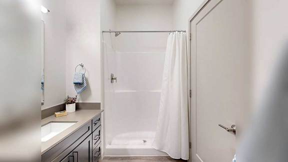 a bathroom with a large mirror, vanity, and modern lighting