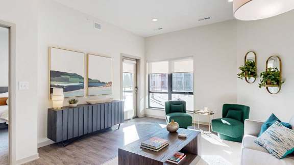 a living room furnished with midcentury modern furniture and a large window and door leading out to a balcony overlooking the courtyard
