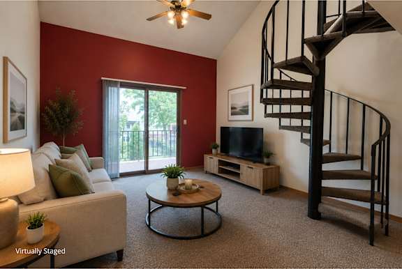 A living room with a spiral staircase and a flat screen TV.