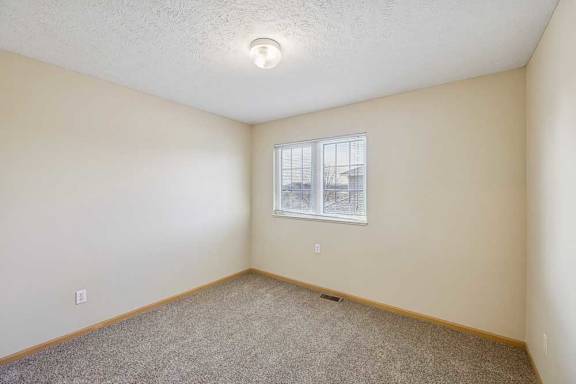A room with a window and a view of buildings outside.