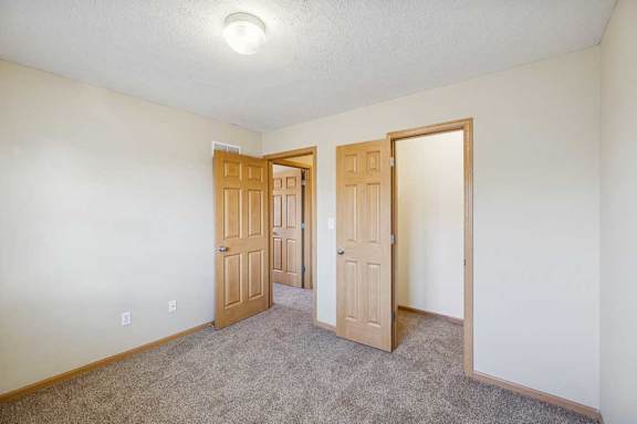 A room with two doors and a carpeted floor.