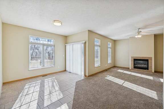 A living room with a fireplace and a rug on the floor.