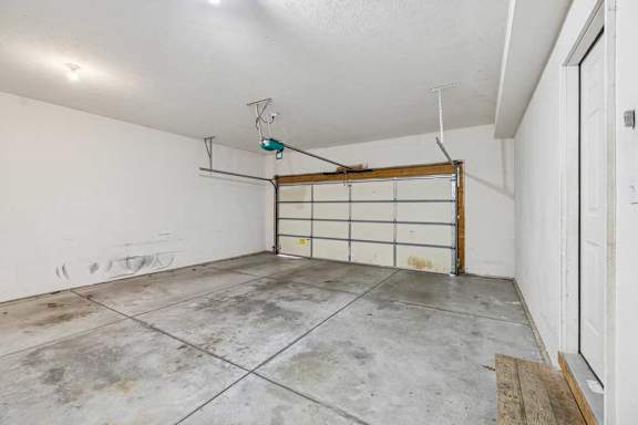 A garage with a white wall and a wooden door.