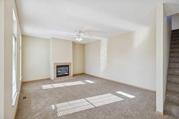 A living room with a fireplace and a carpeted floor.