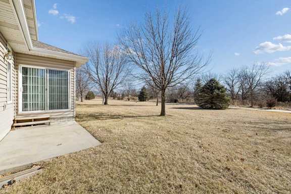 A house with a yard and a tree in the background.