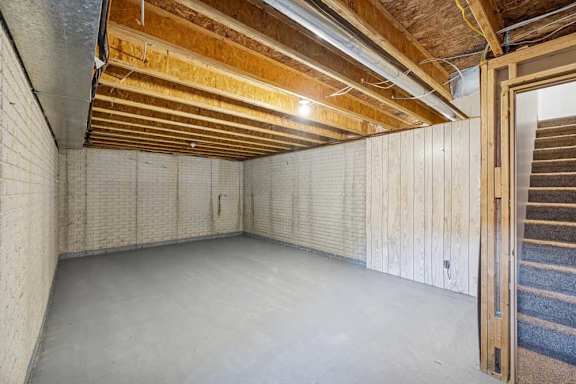 A room with a wooden ceiling and walls, and a door on the right side.