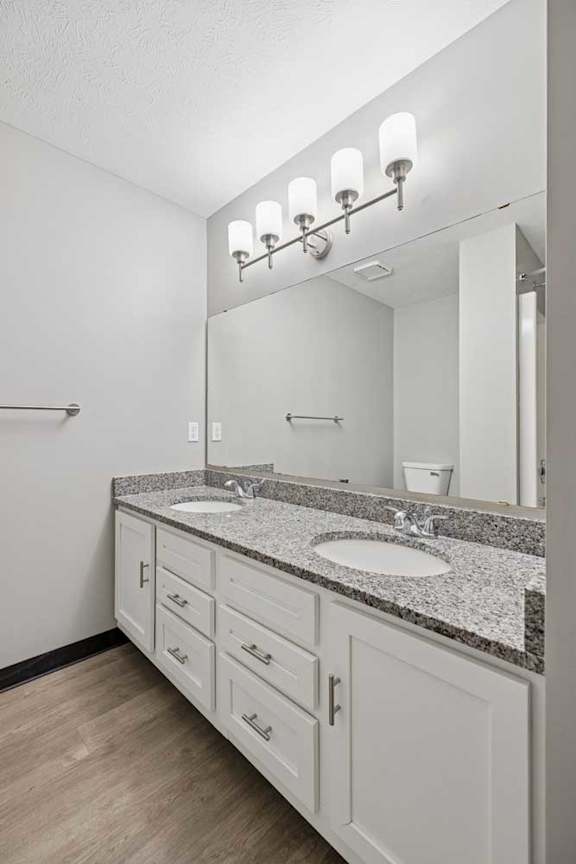A bathroom with a sink, mirror, and lighting fixture.