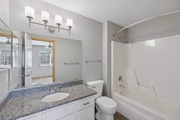 A bathroom with a sink, toilet, and bathtub.