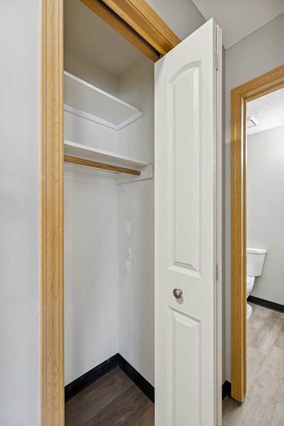 A white door is open to a small, empty room.