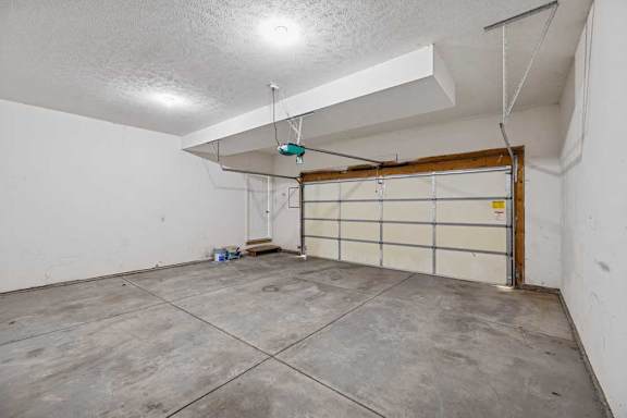 A garage with a white wall and a brown door.