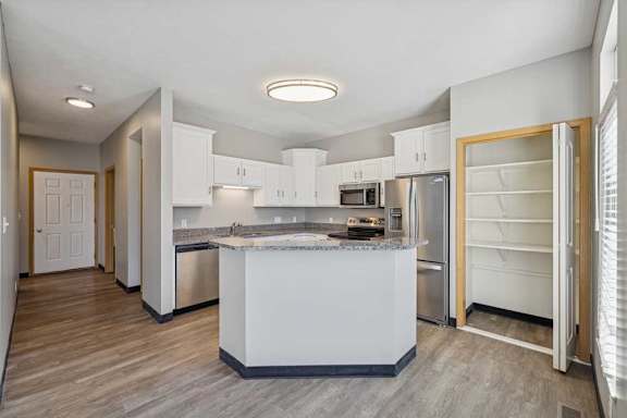 A kitchen with white cabinets and a central island.