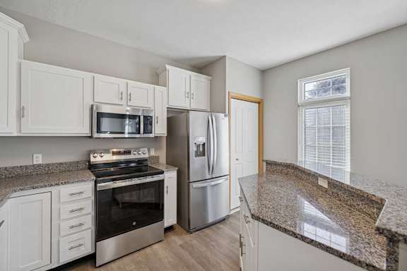 A kitchen with granite countertops and stainless steel appliances.