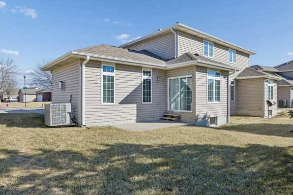 A house with a grey siding and a brown roof.