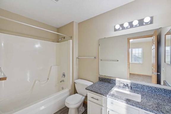 A bathroom with a white toilet, sink, and bathtub.