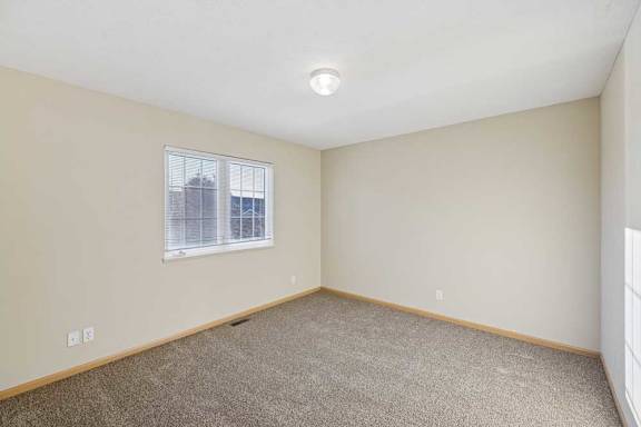 A room with a window and carpeted floor.
