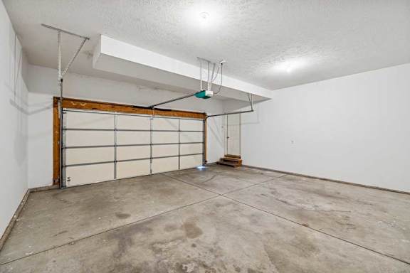 A garage with a white wall and a wooden door.