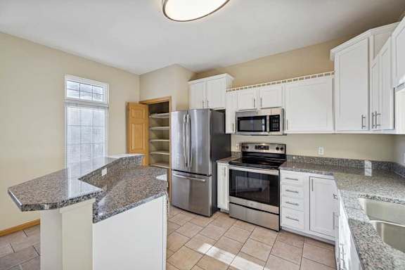 A kitchen with granite countertops and stainless steel appliances.