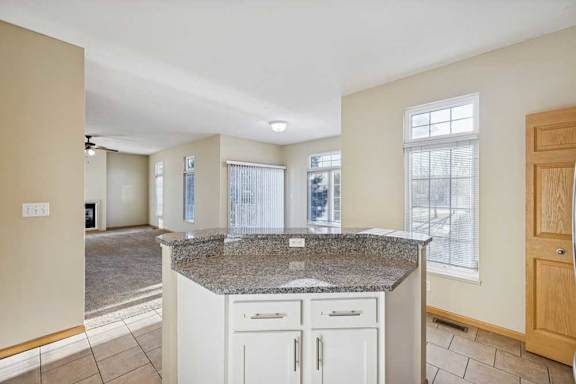 A kitchen with granite countertops and white cabinets.