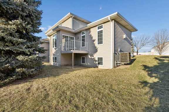 A house with a grey siding and a balcony.