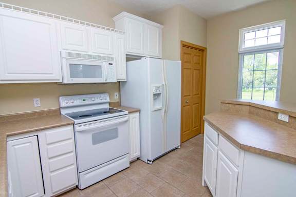 a kitchen with white appliances and white cabinets