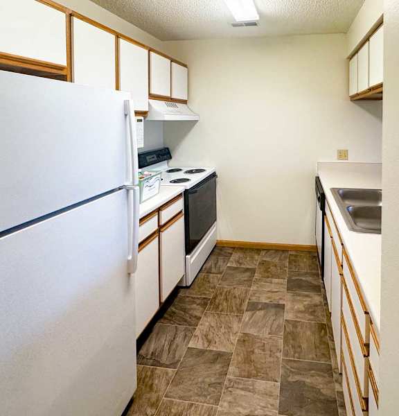 a kitchen with a white appliances and white and brown cabinets