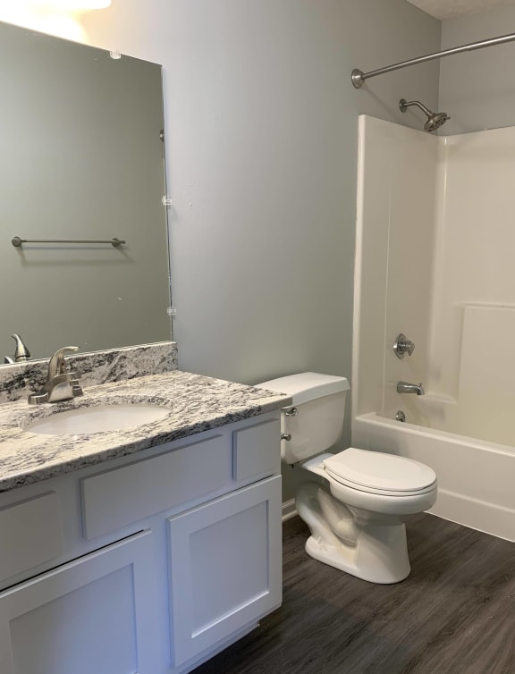 Bathroom with white vanity for storage and large mirror with great lighting at Eagle Run Apartments in Omaha Nebraska