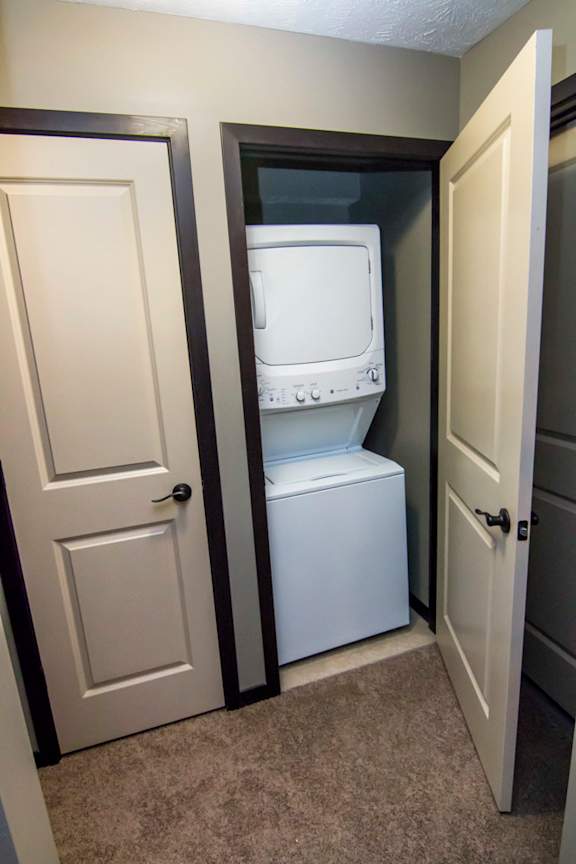 Hall closet with stacked washer and dryer unit
