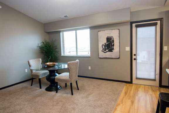 A dining room with a table and chairs.