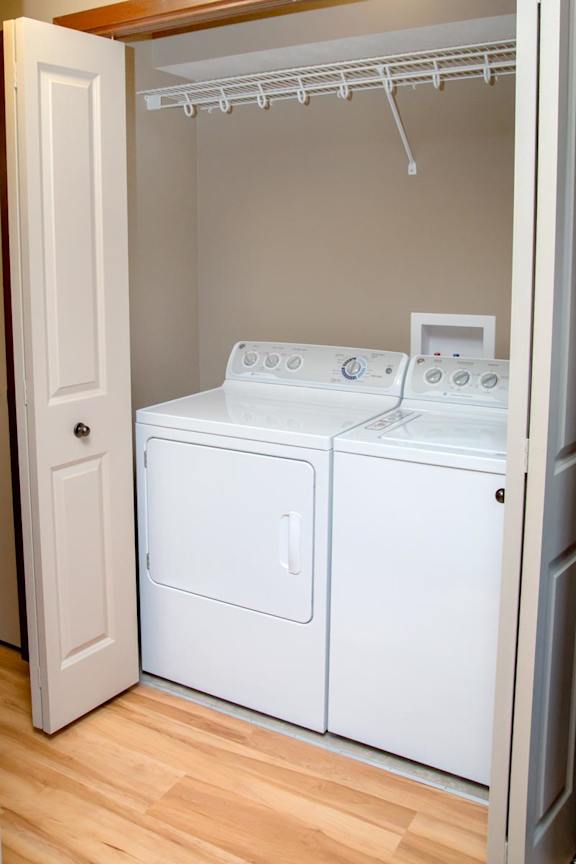 A white washer and dryer in a small laundry closet