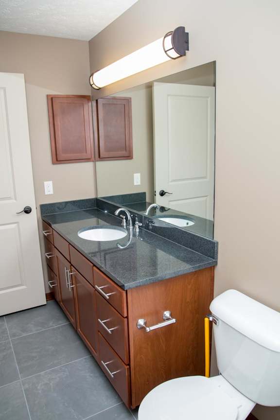 A bathroom with a sink, mirror, and toilet.
