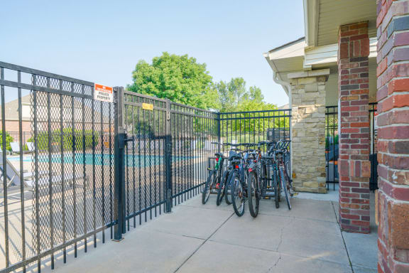 a row of bikes parked in front of a fence that surrounding the pool
