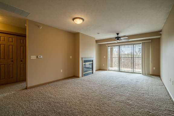 a living room with a fireplace and a ceiling fan